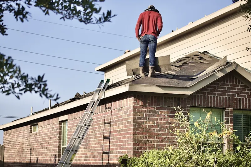 Professional roofer working on a residential roof in Colfax